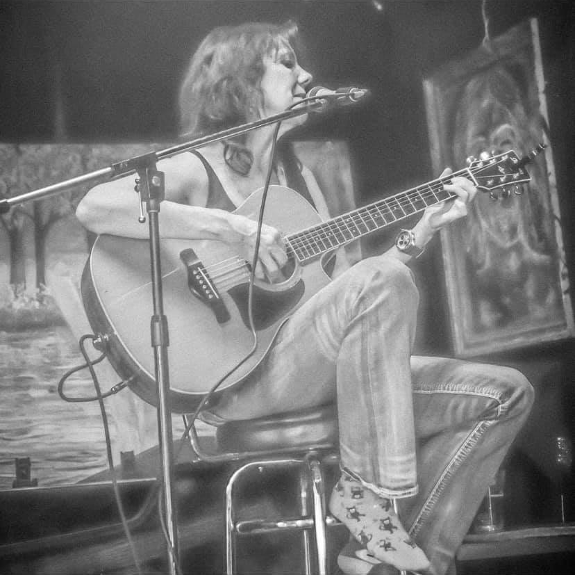 Katrina playing the guitar and singing at the Cove